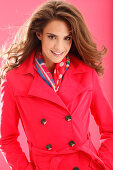 A young brunette woman wearing a red coat and a colourful scarf