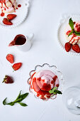 Small strawberry pavlovas drizzled with strawberry sauce