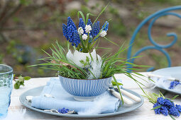 Small bouquet of grape hyacinths in a goose egg as a vase