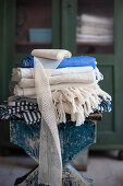 Folded tablecloths and ribbon on stool