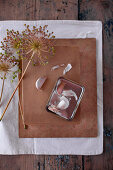 Dried garlic flowers on cardboard box and garlic cloves in tin