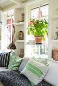 Scatter cushions with various patterns on bench in summerhouse