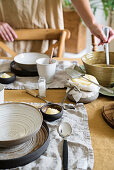 Table set with ceramic crockery and soup being served