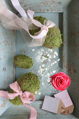 Romantic spring arrangement in muted shades with moss eggs