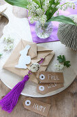 Hand-crafted Easter decorations in natural shades and purple on chopping board