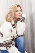 A blonde woman wearing a knitted Norwegian cardigan