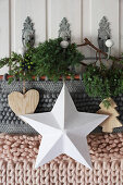 Wall hanging, wooden pendants and sprigs of juniper hanging from wall hooks