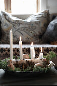Advent arrangement of four candles on piece of birch bark in dish