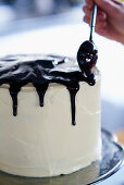 Decorating malt chocolate cake with chocolate icing