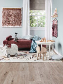 Children's table with chair and doll's pram in front of daybed