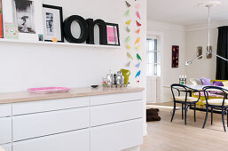 Decorative letters on picture ledge above kitchen counter next to open-plan dining room