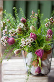 Bouquet of tulips, shepherd's purse and Australian waxflowers in wire basket with eggs
