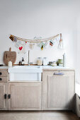 Wooden pearl necklace and greeting cards above the kitchen unit with sink