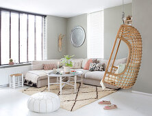 Hanging chair in the boho style living room with large windows