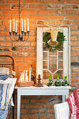 Christmas arrangement with deer head, wreath, candles, and hyacinths in front of brick wall