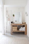 Wooden table with countertop basin in a white corner of the bathroom