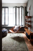 Classic leather chair and cabinet shelf in the living room with shutters