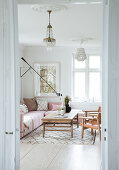 Pink upholstered sectional sofa, rustic coffee table, and leather chairs in the living room