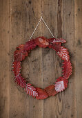 Wreath of red autumn leaves with white decoration