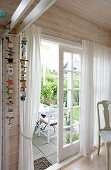 Wind chimes hang next to the open bar door to the terrace