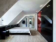 Floor-to-ceiling closet with sliding doors and double bed under the eaves in a bedroom