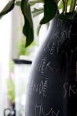 Black vase decorated with white handwriting