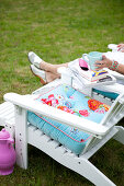 White deck chair with colorful pillows in the garden