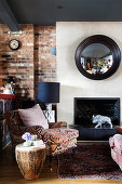 Armchair with ethnic cover an African drum as a side table in front of the fireplace