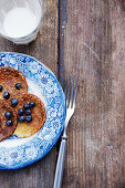 Pancakes with blueberries on a blue-and-white porcelain plate
