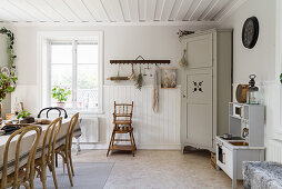 Bistro chairs around dining table with tablecloth in rustic kitchen-dining room