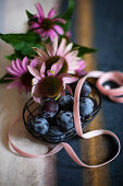 Basket of plums, ribbon and Echinaceas