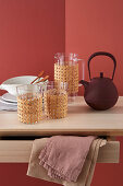 Glasses and jug with Viennese cane covers, teapot and plates on table