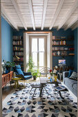 Rug with geometric pattern in living room with blue walls and retro furnishings