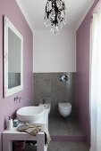 Toilet, tiled floor and pastel lilac walls in elegant bathroom