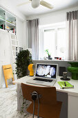 Home workspace on folding table behind partition in studio apartment