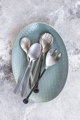 Spoons and salad servers on an oval serving platter