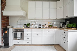 Small log burner in kitchen in Scandinavian country-house style