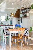 Spoke-back bench and various chairs around table in kitchen-dining room