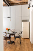 White retro fridge in niche in floor-to-ceiling fitted cupboards