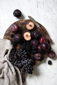 Autumn fruits: red grapes, blackberries and plums on a wooden board