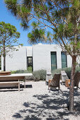 Deckchairs and wooden tables in gravel courtyard