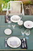 Gedeckter Tisch auf Terrasse in Blau-Weiß mit Designerstuhl aus Schnürbespannung