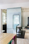 View from living area into kitchen-dining room separated by glass wall