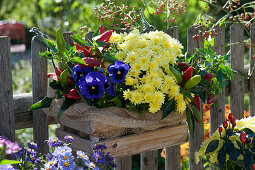 Wooden box with peppers, autumn chrysanthemum, and pansies by the garden fence