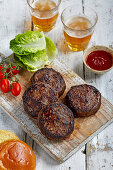 Burger-Patties vom Angusrind auf Holzbrett