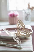 Delicate paper butterfly on plate decorating table