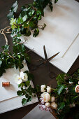 Ivy tendrils and fabric flowers arranged with framed pictures painted over in white