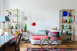 Designer sofa with colourful scatter cushions, shelving units and coffee table in 70s-style living room