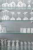 Upturned glasses on glass shelves