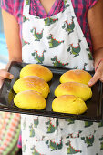 Homemade burger buns on a baking tray